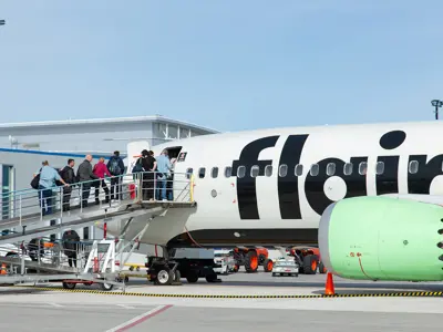 Passengers boarding a Flair Airlines plane in the summer