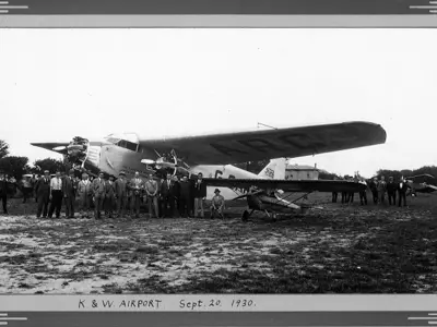 Group of people standing in front of Ford plane