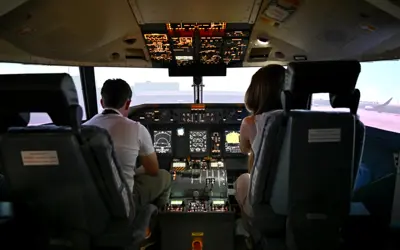 Two people in the Aviation SIM at the Waterloo Wellington Flight Centre